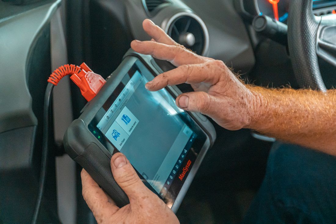 Diagnostic scan tool being used inside a vehicle